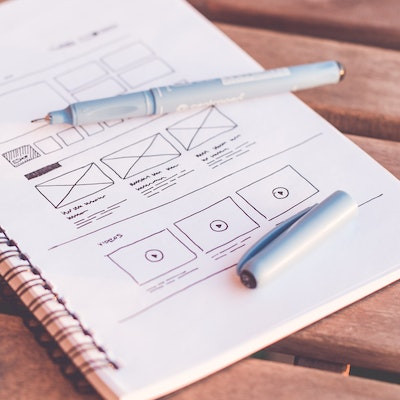 A notebook with a sketch of a website wireframe